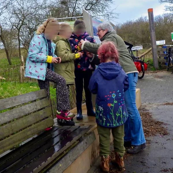 Kinderen ontdekken samen de camera tijdens een fotofeestje buiten in de natuur